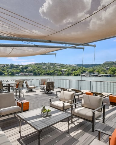 Waterfront deck with retractable shade, lounge seating, and river view with forested hills